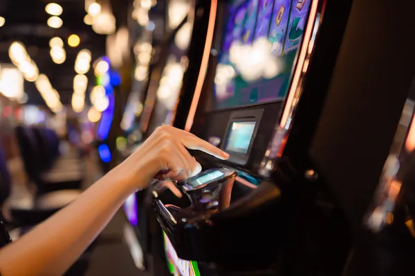 Une jeune femme se détend avec son téléphone tandis que des éléments de casino flottent autour d'elle, illustrant l'expérience mobile fluide proposée par l'application KWANZA.