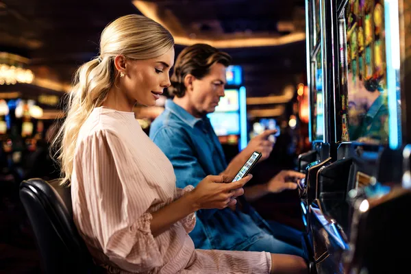 Un homme célèbre un moment gagnant sur son ordinateur tandis que des symboles de jeu flottent autour de lui, capturant l'énergie des jeux KWANZA.