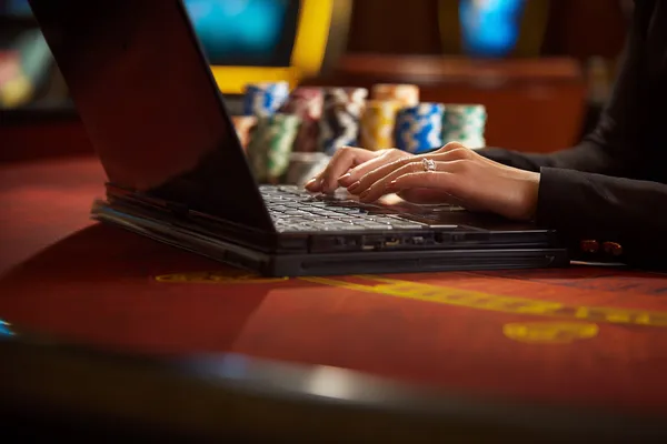 Une roulette lumineuse entourée de jetons symbolise les jeux en direct et les formats instantanés disponibles sur KWANZA.